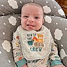 Enzo is registered to the contest to win money with this photo: baby, smiling, tongue_out, bib, baby_clothes, cloud_pattern, cushion, infant, happy, cute, indoor, child, person, sitting, portrait, hand, face, newborn, cozy, playful