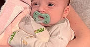 Enzo joined the competition — help win amazing prizes! baby, pacifier, infant, person, hand, blanket, towel, clothing, arm, skin, newborn, comfort, resting, cute, holding, indoors, soft, white, pink, green