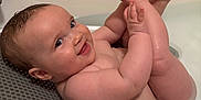 Isabelle joined the competition — help win amazing prizes! baby, bath, water, smile, child, skin, hand, foot, happy, indoors, cute, toddler, head, face, playful, naked, sitting, person, bathroom, skin_tone