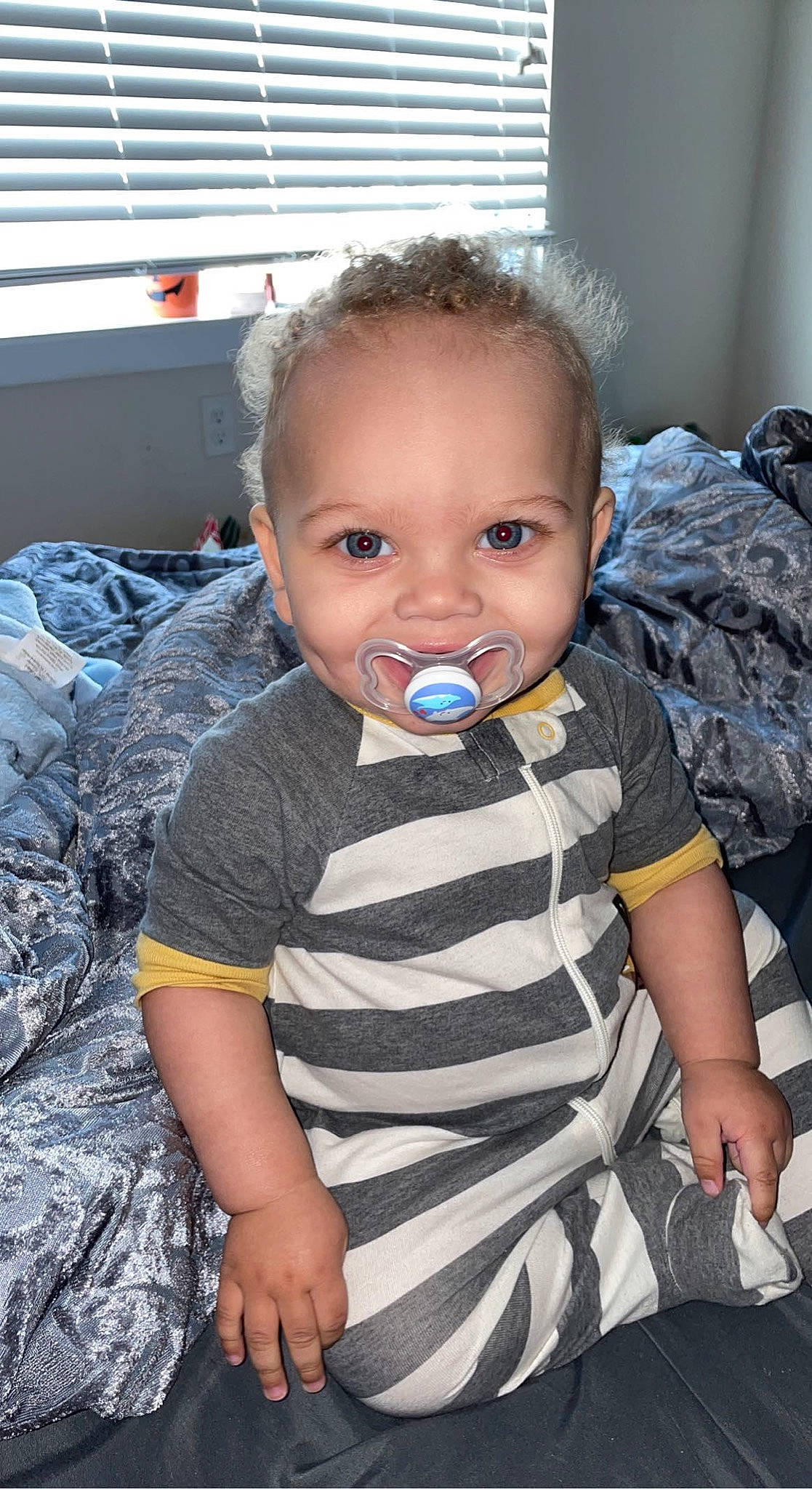 Aceton is registered to the contest to win money with this photo: baby, baby_toddler_clothing, camouflage, cheek, child, chin, comfort, eye, flooring, fun, hair, happy, head, iris, military_camouflage, person, sitting, skin, sleeve, t_shirt