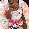Kiari joined the competition — help win amazing prizes! baby, child, infant, smile, happy, pink, bib, clothing, pattern, floral, cushion, sitting, cute, face, portrait, leopard_print, sock, hand, fist, indoor