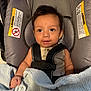 baby, car_seat, blanket, infant, child, seatbelt, smiling, indoors, cute, young_child, clothing, safety, portrait, face, hands, fabric, cushion, head, baby_girl, baby_boy