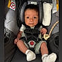 baby, infant, car_seat, safety_harness, pacifier, white_socks, short_sleeves, newborn, child, cute, seat, straps, head_support, fabric, indoors, human, tiny_hands, expression, looking, resting