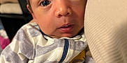 Nestor is registered to the contest to win money with this photo: baby, infant, face, eyes, onesie, clothing, striped, yellow, hand, cozy, indoor, closeup, portrait, soft, curious, person, newborn, cute, warm, comfort