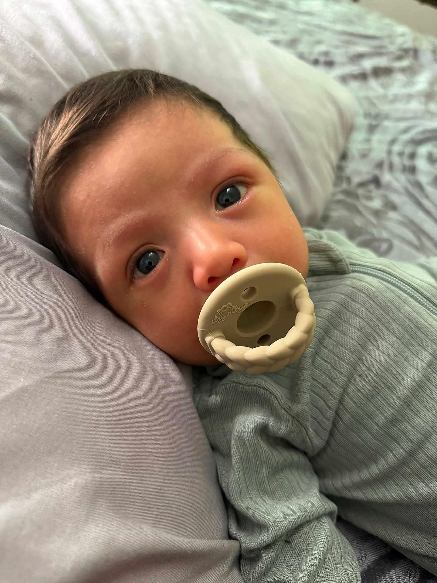 Nestor joined the competition — help win amazing prizes! baby, infant, pacifier, pillow, close_up, face, blue_eyes, ribbed_clothing, lying_down, bed, blanket, soft_light, skin, cute, child, portrait, indoors, young, head, resting