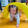 Iris a rejoint le concours — aidez-le/la à gagner de superbes lots ! child, girl, pigtails, yellow_arch, crawling, indoor, playground, floor, happy, smiling, kids, toys, play, colorful, casual_clothing, curious, fun, young, activity, daylight