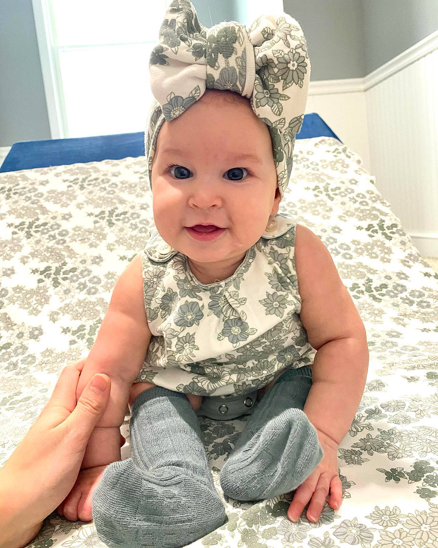 Xiomara is registered to the contest to win money with this photo: baby, baby_toddler_clothing, cap, child, fashion_accessory, flooring, fun, happy, headband, headgear, headpiece, headwear, pattern, person, photograph, sitting, skin, sleeve, smile, standing