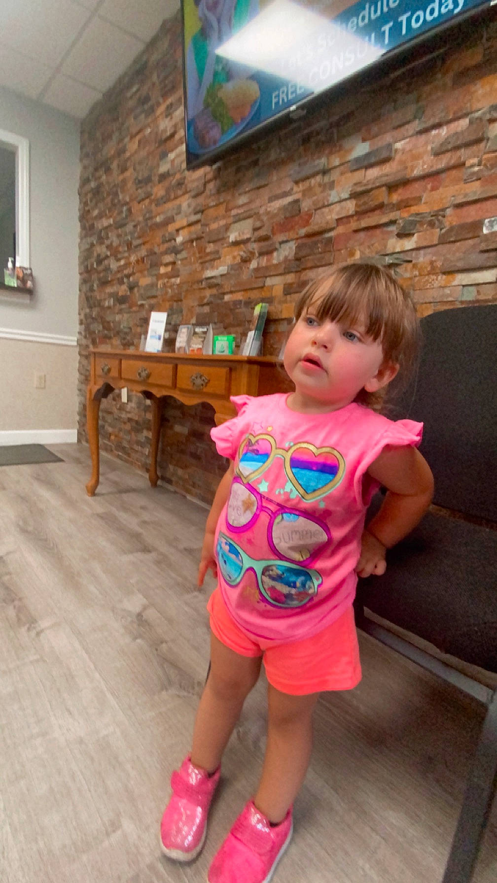 Raelynn joined the competition — help win amazing prizes! baby_toddler_clothing, child, door, floor, flooring, fun, happy, hardwood, leg, leisure, magenta, person, picture_frame, pink, sandal, shorts, sitting, t_shirt, toddler, wood