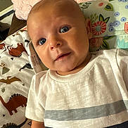 Colten is registered to the contest to win money with this photo: baby, blanket, blue_eyes, child, closeup, cute, dinosaur_pattern, expression, face, floral_pattern, head, indoor, infant, lying_down, pillow, portrait, skin, striped_shirt, white_shirt, young