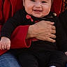 baby, being_held, black_clothing, blue_jeans, child, close_up, cute, face, family, hand, happy, indoor, infant, parent, photography, portrait, red_fabric, sitting, smiling, striped_socks