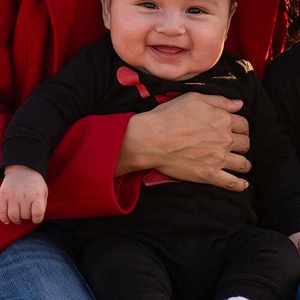 Yancy Noemy Torres joined the competition — help win amazing prizes! baby, being_held, black_clothing, blue_jeans, child, close_up, cute, face, family, hand, happy, indoor, infant, parent, photography, portrait, red_fabric, sitting, smiling, striped_socks