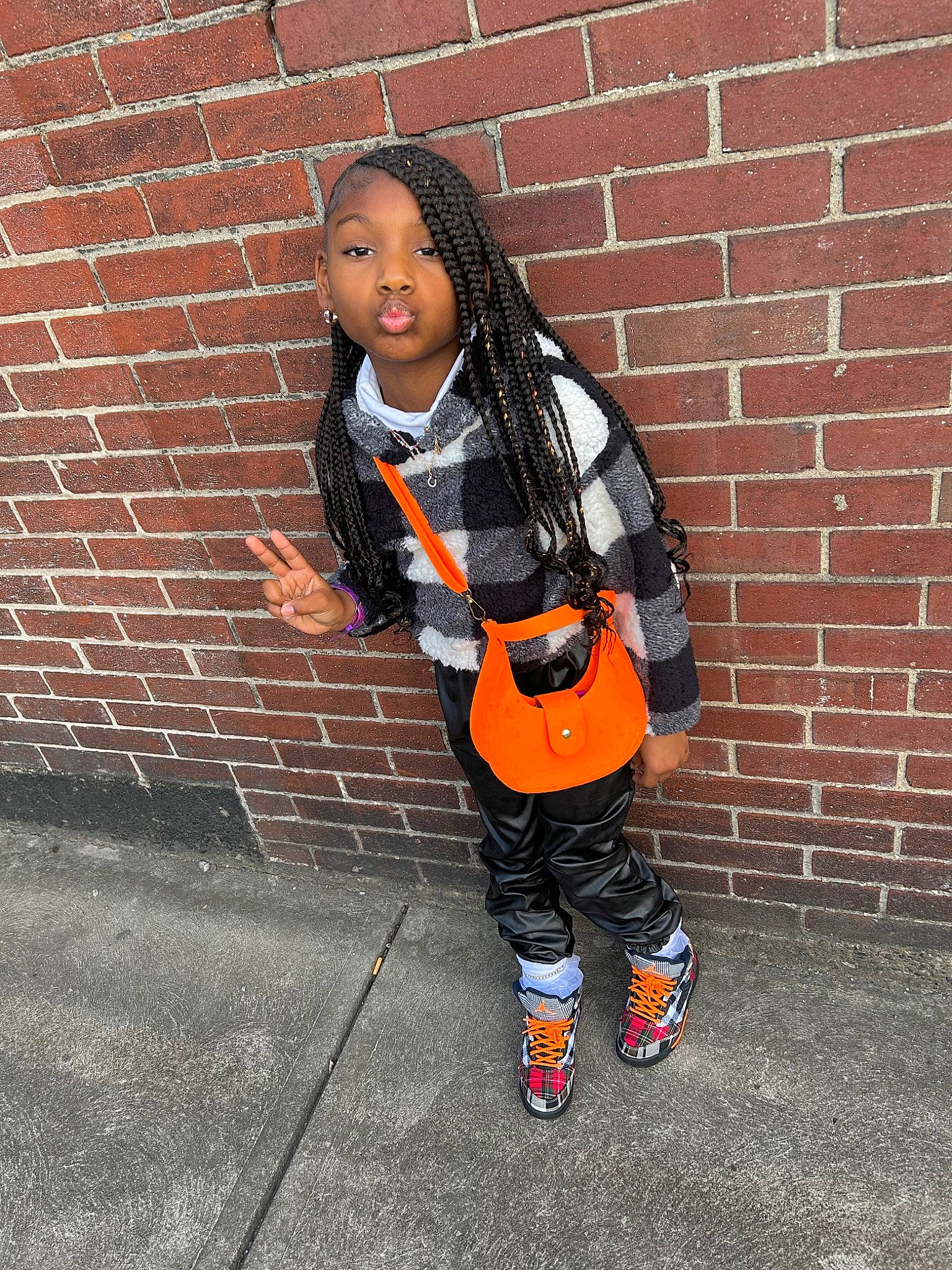 Desire is registered to the contest to win money with this photo: asphalt, bag, brick, brickwork, carmine, denim, fashion_accessory, human_leg, knee, orange, pattern, person, personal_protective_equipment, plaid, scarf, sleeve, sportswear, t_shirt, thigh, toddler