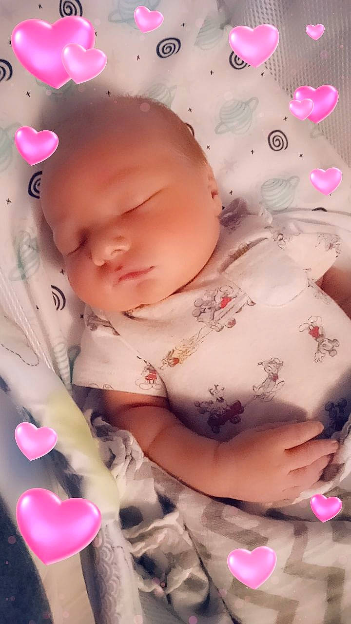 Elijah is registered to the contest to win money with this photo: arm, baby, baby_products, baby_sleeping, baby_toddler_clothing, cheek, finger, happy, human_body, lip, magenta, mouth, nail, pattern, peach, person, petal, pink, skin, toddler