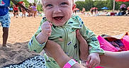 Sy is registered to the contest to win money with this photo: baby, beach, blanket, child, clouds, family, fun, hand, happy, onesie, outdoor, person, playing, sand, sky, smile, summer, sunny, umbrella, vacation