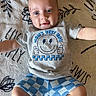 Sy joined the competition — help win amazing prizes! baby, blanket, blue, child, clothing, cute, expression, face, grey, happy, indoors, infant, lying_down, pattern, person, shorts, skin, smiling, toddler, tshirt