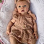 Ivy-Rose is registered to the contest to win money with this photo: baby, infant, crocheted_clothing, headband, blanket, pink, outdoor, grass, soft_texture, cute, portrait, child, newborn, hand, footwear, expression, laying_down, natural_light, face, person