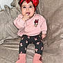 baby, blanket, child, clothing, cute, face, fingers, happy, headband, indoor, infant, minnie_mouse, patterned_leggings, pink_socks, pink_sweater, portrait, red_bow, sitting, smiling, toddler