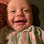 Rosalie is registered to the contest to win money with this photo: baby, smiling, face, close_up, infant, child, cozy, blanket, clothing, patterned, texture, portrait, young, cute, happy, indoor, soft, warm, expression, person