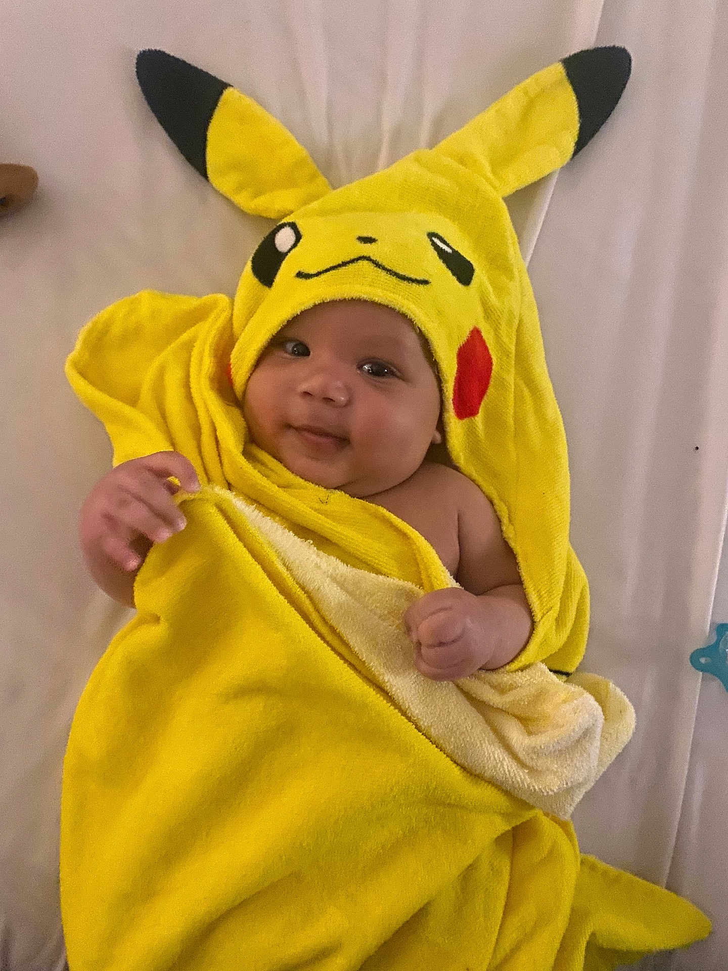 Aahil joined the competition — help win amazing prizes! adorable, baby, blanket, child, comfort, cute, expression, face, hand, hood, indoors, infant, lying_down, pikachu, skin, smiling, soft, towel, wrapped, yellow