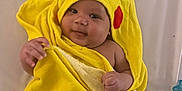 Aahil joined the competition — help win amazing prizes! baby, blanket, child, comfort, cute, expression, face, hand, hooded_towel, indoors, infant, lying_down, person, pikachu, skin, smile, soft, towel, warm, yellow
