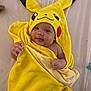 Aahil joined the competition — help win amazing prizes! baby, child, towel, pikachu, yellow, cute, face, smile, indoors, soft, blanket, hooded_towel, person, infant, skin, hand, lying_down, comfort, warm, expression