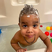 Amir joined the competition — help win amazing prizes! toddler, child, bathtub, foam, shampoo, water, colorful_balls, bath_time, smiling, face, hands, necklace, wet_skin, indoor, playful, cute, portrait, young_child, happy, looking_up