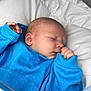 baby, bed, blanket, blue_sweater, child, closeup, clothing, cozy, cute, face, hand, indoor, infant, newborn, peaceful, portrait, resting, skin, sleeping, soft
