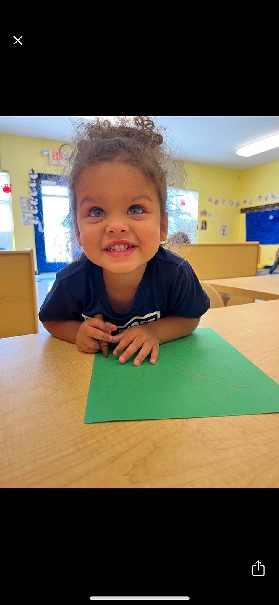 Kyrie joined the competition — help win amazing prizes! chair, child, desk, flooring, fun, happy, joy, kindergarten, learning, office_supplies, person, play, room, school, sitting, smile, t_shirt, table, toddler, wood