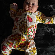 Emma joined the competition — help win amazing prizes! baby, infant, child, onesie, pizza_print, pajamas, lying_down, face, eyes, chubby_cheeks, portrait, cute, hand, leg, bed, blanket, dark_background, soft_light, expression, sleepwear