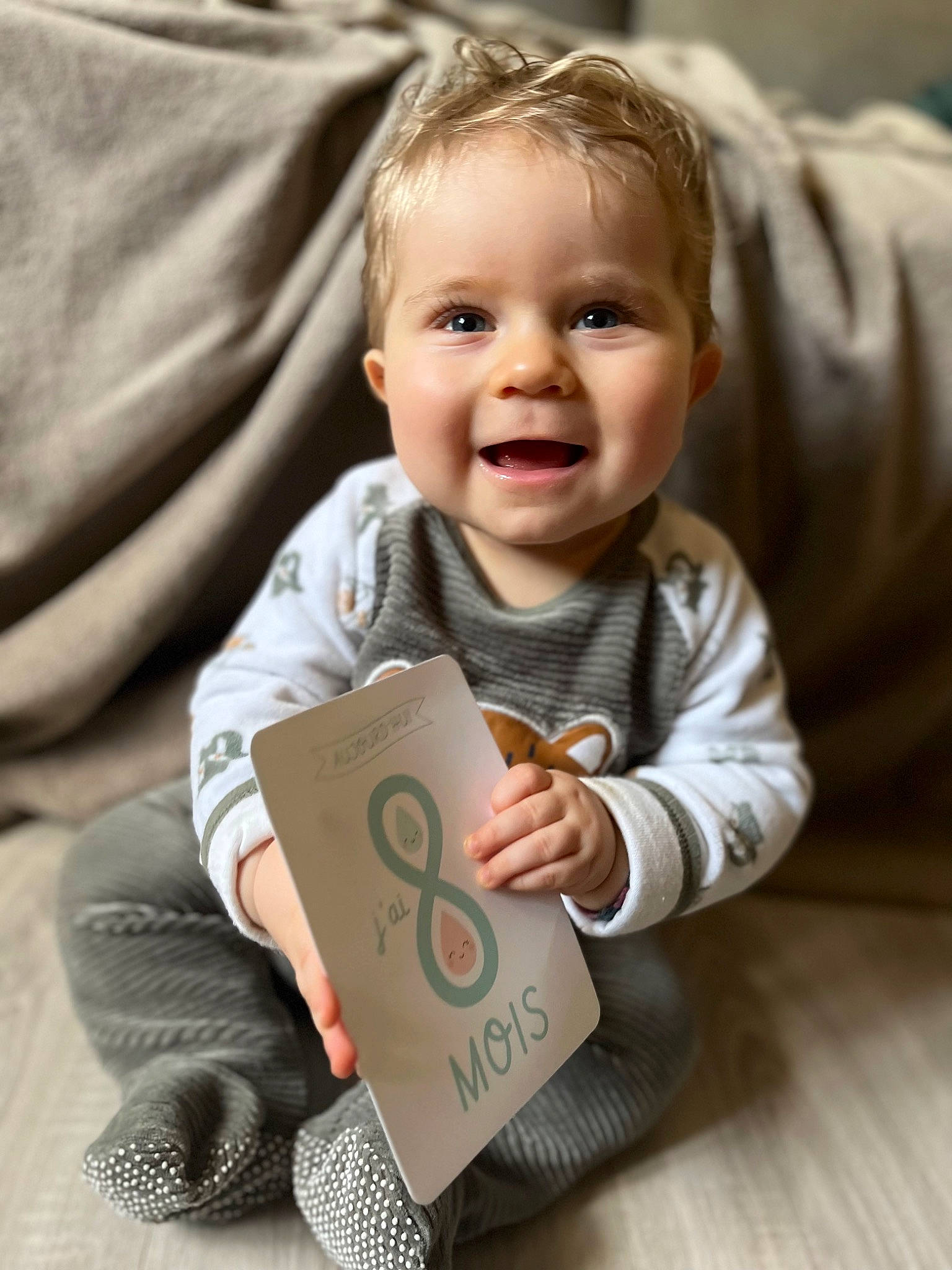 Jules participe au concours pour gagner de l'argent avec cette photo : baby, baby_toddler_clothing, cheek, child, comfort, fun, gadget, happy, outerwear, pattern, person, product, room, sitting, skin, sleeve, smile, standing, t_shirt, toddler