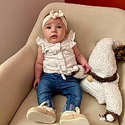 Jannah a rejoint le concours — aidez-le/la à gagner de superbes lots ! armchair, baby, beige_wall, child, curious, cute, expression, frilly_top, furniture, gnome, hand_holding, headband, indoor, jeans, plush_toy, portrait, red_wall, seated, shoes, soft_toy