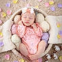 baby, newborn, sleeping, headband, flower_petals, petals, yarn_balls, basket, blanket, lace_outfit, pastel_colors, cozy, infant, portrait, studio_photo, knitted_yarn, cotton_branch, soft_texture, peaceful, props