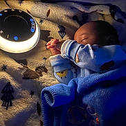 Zayvion is registered to the contest to win money with this photo: baby, sleeping, blanket, blue_blanket, nightlight, fleece, patterned_fabric, hand, cozy, bedtime, infant, pajamas, soft_light, indoor, rest, peaceful, comfort, child, cute, portrait