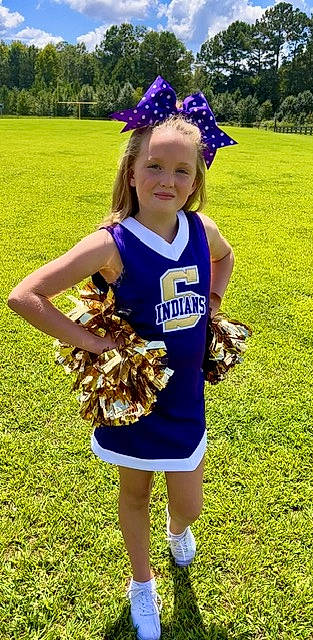 Braylie is registered to the contest to win money with this photo: blond, blue, cheerleading_uniform, electric_blue, fun, gesture, glove, grass, hair, happy, jersey, joy, person, player, smile, sports, sports_uniform, sportswear, team_sport, thigh