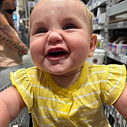 Emberleigh joined the competition — help win amazing prizes! baby, child, shopping_cart, yellow_clothing, smiling, happy, portrait, face, store_aisle, adult, tattoo, blurred_background, indoor, retail, infant, closeup, cute, person, casual, daylight