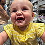 baby, child, shopping_cart, yellow_clothing, smiling, happy, portrait, face, store_aisle, adult, tattoo, blurred_background, indoor, retail, infant, closeup, cute, person, casual, daylight