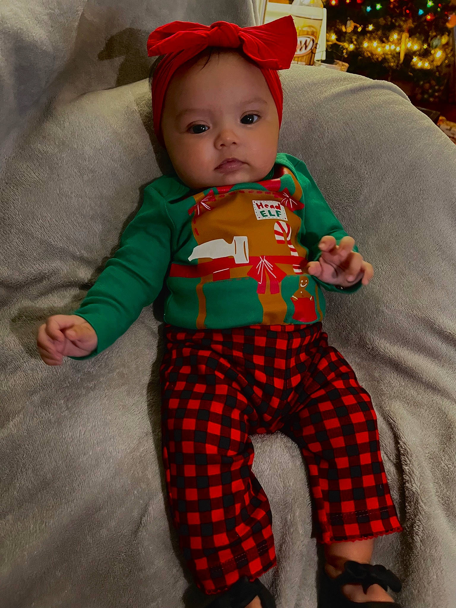 Lylah joined the competition — help win amazing prizes! baby, baby_toddler_clothing, child, christmas, christmas_ornament, christmas_tree, event, fictional_character, fun, head, holiday, orange, pattern, person, plaid, sleeve, sock, standing, textile, toddler