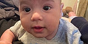 Jamiel joined the competition — help win amazing prizes! baby, infant, face, eyes, mouth, arm, clothing, blanket, bed, pillow, indoor, person, skin, head, expression, candid, closeup, curious, young_child, toddler
