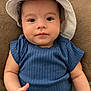 Jamiel is registered to the contest to win money with this photo: baby, infant, child, blue_clothing, hat, sun_hat, cute, lying_down, blanket, soft_texture, face, portrait, expression, hand, skin, indoors, young, one_person, looking_at_camera, casual