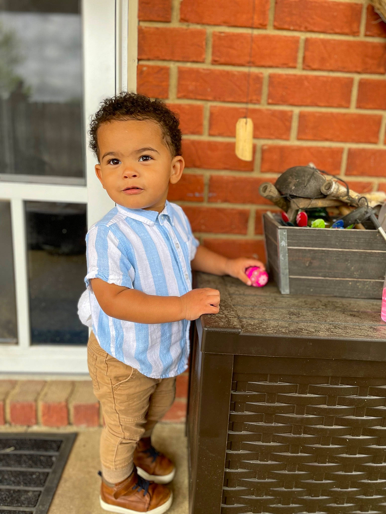 Kylo is registered to the contest to win money with this photo: baby_toddler_clothing, brick, brickwork, child, flooring, fruit, happy, leisure, person, play, room, sandal, shorts, sitting, soil, standing, t_shirt, toddler, travel, window