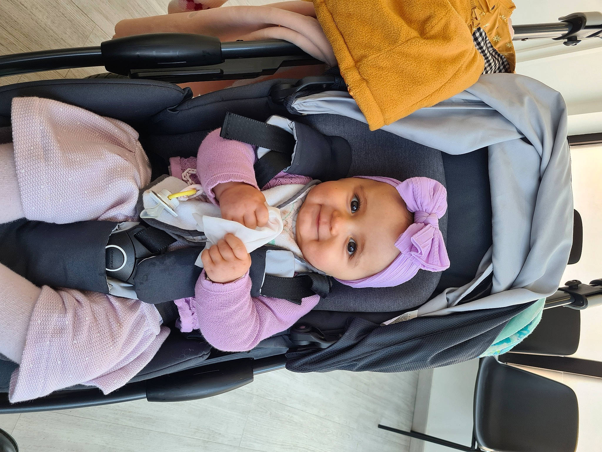 Ana participe au concours pour gagner de l'argent avec cette photo : baby, baby_carriage, baby_products, baby_safety, baby_toddler_clothing, car_seat, child, comfort, headwear, joy, lap, person, purple, smile, toddler