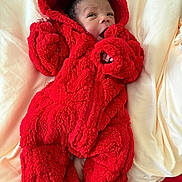 Bernard joined the competition — help win amazing prizes! baby, infant, red_onesie, fluffy_clothing, hooded_outfit, blanket, bed, cute, newborn, child, face, sleepwear, soft_texture, cozy, lying_down, warm_clothing, indoors, portrait, small_hands, baby_clothes