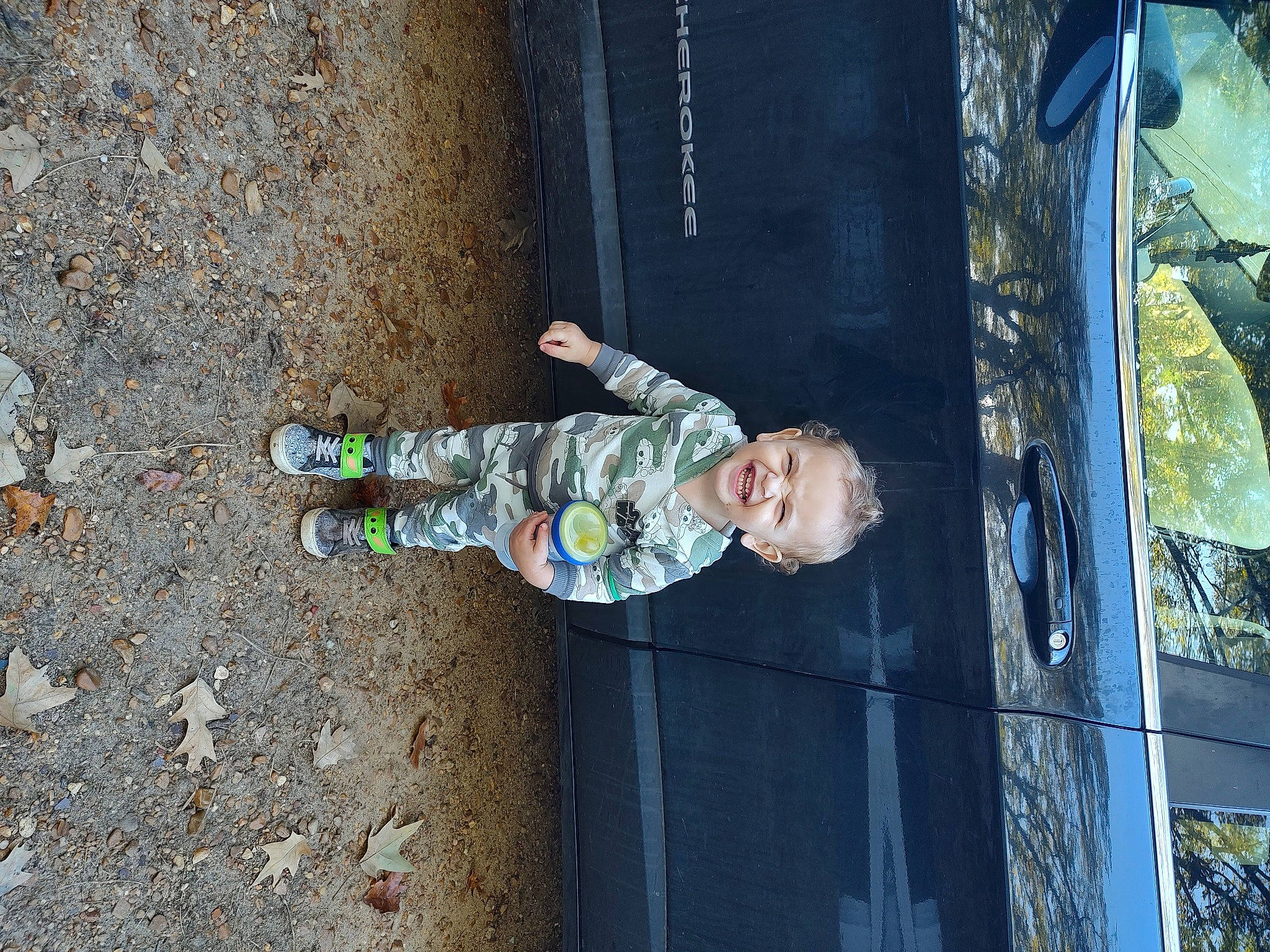 Briar is registered to the contest to win money with this photo: asphalt, baby, baby_toddler_clothing, child, concrete, fun, joy, person, plant, road_surface, shadow, smile, soil, toddler, tree, walking_shoe, wood