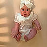 baby, infant, child, headband, bow, cute, sitting, soft_lighting, beige_background, portrait, chubby_cheeks, curious_expression, clothing, ruffles, skin, hands, feet, closeup, indoor, young
