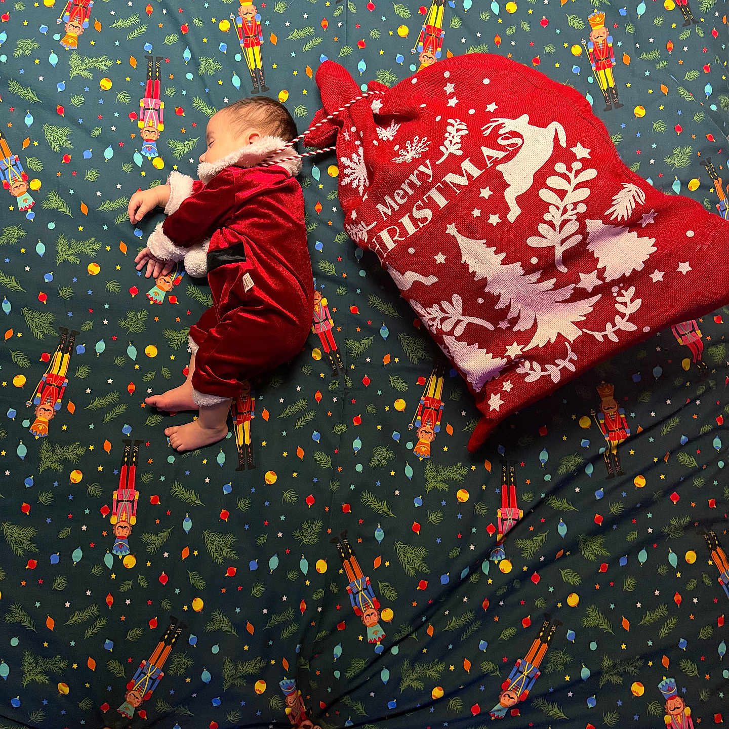 Flavio Massimo participe au concours pour gagner de l'argent avec cette photo : baby, blanket, celebration, child, christmas_sack, cozy, decor, feet, festive, holiday, indoor, infant, nutcracker_pattern, pattern, person, red_clothing, sleep, sleeping, toes, velvet