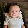 Scheffen is registered to the contest to win money with this photo: baby, child, face, smile, blue_eyes, curly_hair, wooden_bowl, pillow, greenery, wood_floor, cozy, portrait, indoor, cute, infant, clothing, short_sleeve, relaxed, skin, person