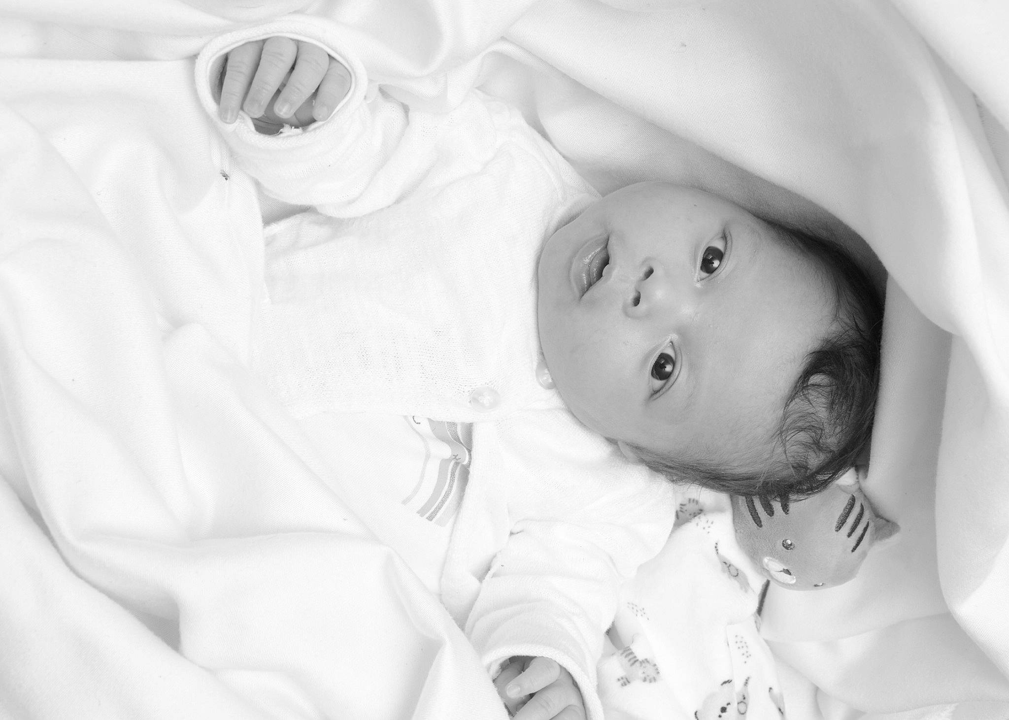 Malia participe au concours pour gagner de l'argent avec cette photo : baby, bedtime, cheek, child, comfort, eyebrow, eyelash, fun, gesture, happy, iris, linens, lip, monochrome, monochrome_photography, nose, person, portrait_photography, skin, toddler