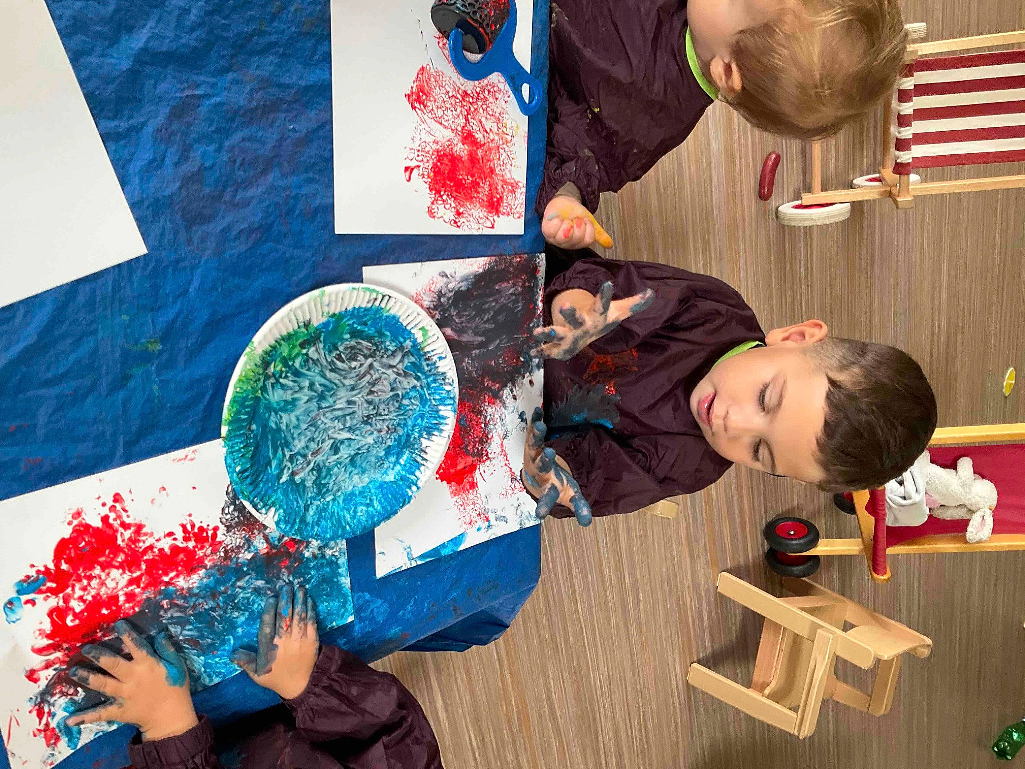 Aylan participe au concours pour gagner de l'argent avec cette photo : adaptation, art, artist, blue, child, education, electric_blue, flag, fun, leisure, pattern, person, play, recreation, red, sharing, sitting, t_shirt, toddler, visual_arts