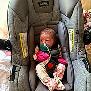 Haven is registered to the contest to win money with this photo: baby, baby_girl, car_seat, child, cozy, cute, evenflo, face, floral_pajamas, indoor, infant, newborn, pacifier, person, pink_mittens, safety, seatbelt, sitting, small, wrapped
