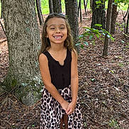 Madison joined the competition — help win amazing prizes! child, girl, smiling, forest, tree, leaves, nature, outdoor, dress, black_top, leopard_print, gold_shoes, standing, happy, young, sunlight, plant, woodland, casual_clothing, person